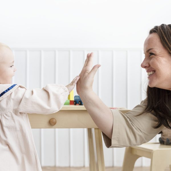 Mother and baby daughter giving high fives