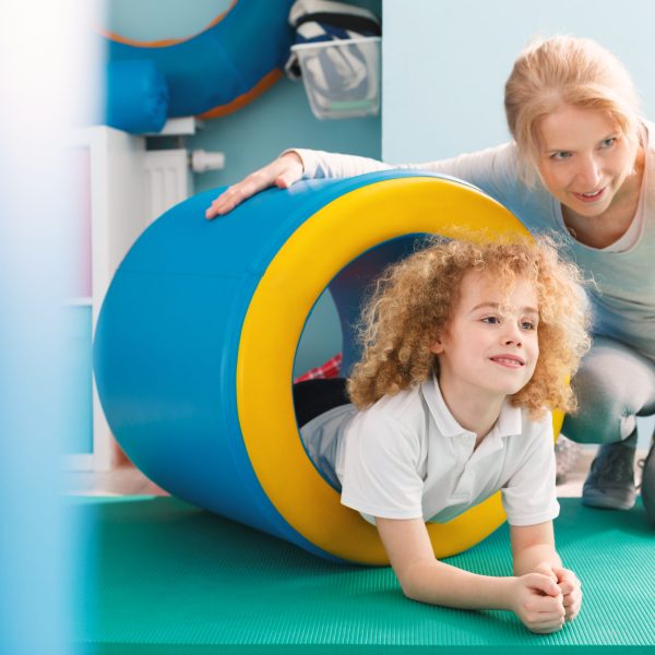 Professional therapist explaining new exercise to a little boy
